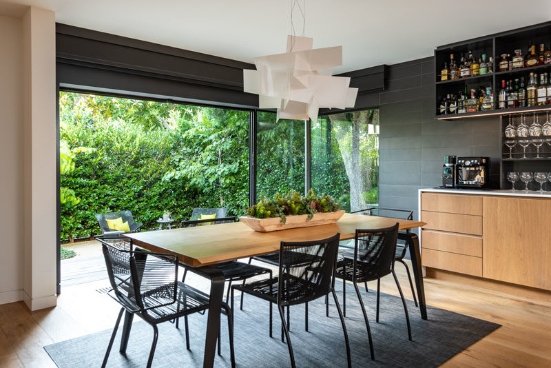 This modern and open plan dining room has sliding glass doors that open up an outdoor space. #ModernDiningRoom #DiningArea #SlidingGlassDoors #DiningRoomIdeas