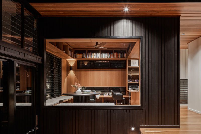 This modern home office has bench seating that lines the corner, a desk, and built-in shelving. #HomeOfficeIdeas #ModernHomeOffice