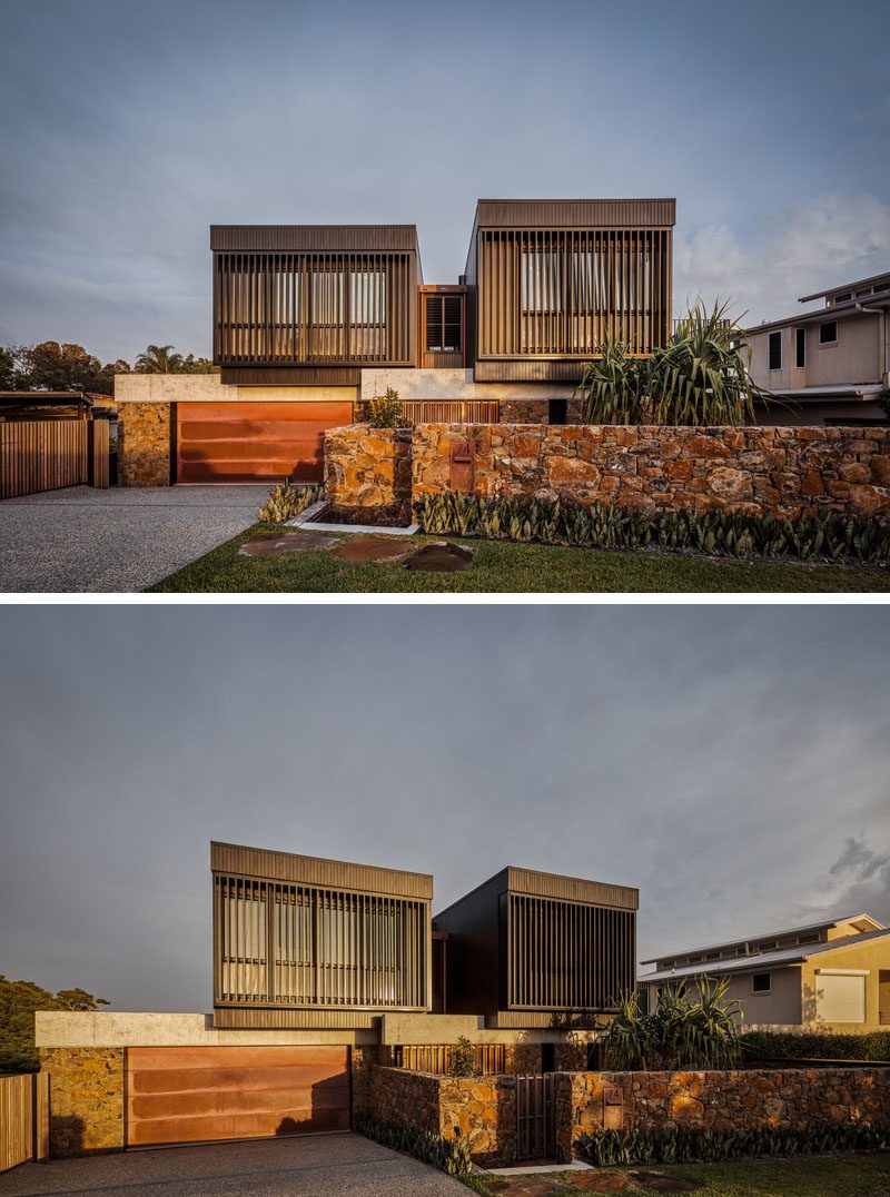 At the front of this modern house are two boxes that sit atop the ground level, and have louvres for privacy, security, and ventilation. #ModernHouse #HouseDesign #StoneWall #ModernArchitecture #Louvres