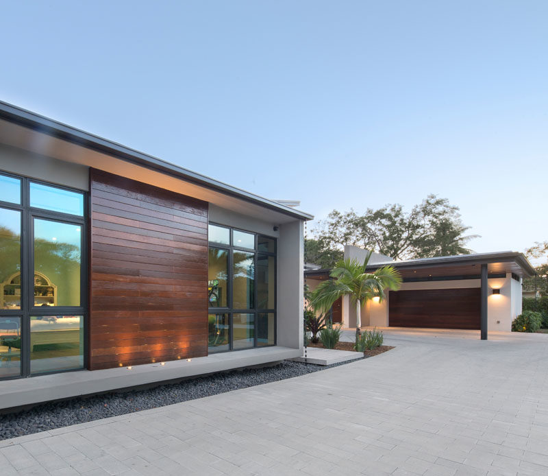 Taking advantage of the site’s oversized width, the design of this modern house was conceived as a series of strategically placed volumes that create interior and exterior courtyards. #Architecture #ModernHouse