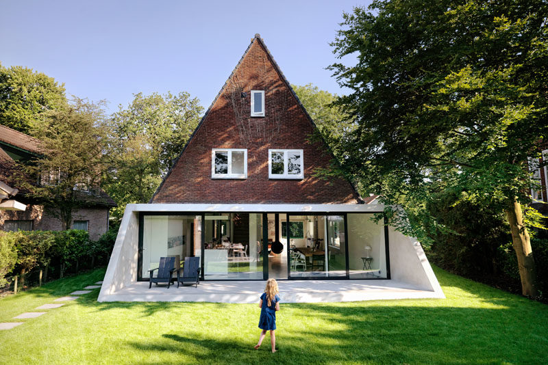 Architecture Ideas - This brick house received a new angled addition, that enlarged it with an open floor plan, added a view to the garden, and continues the slope of the original roof. #ModernArchitecture #HouseAddition #GlassWall