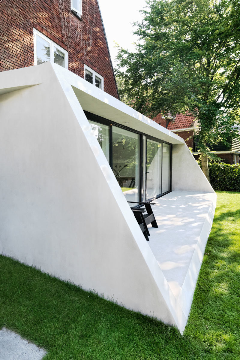 Architecture Ideas - This brick house received a new angled addition, that enlarged it with an open floor plan, added a view to the garden, and continues the slope of the original roof. #ModernArchitecture #HouseAddition #GlassWall