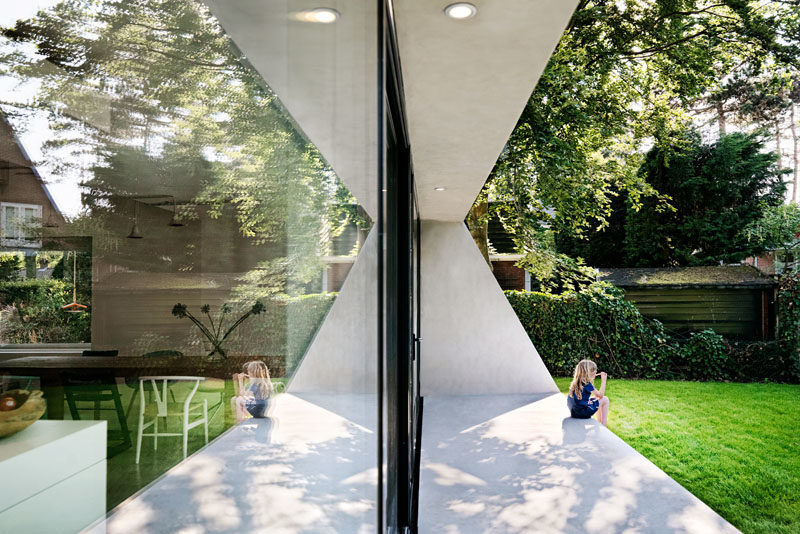 Architecture Ideas - This brick house received a new angled addition, that enlarged it with an open floor plan, added a view to the garden, and continues the slope of the original roof. #ModernArchitecture #HouseAddition #GlassWall