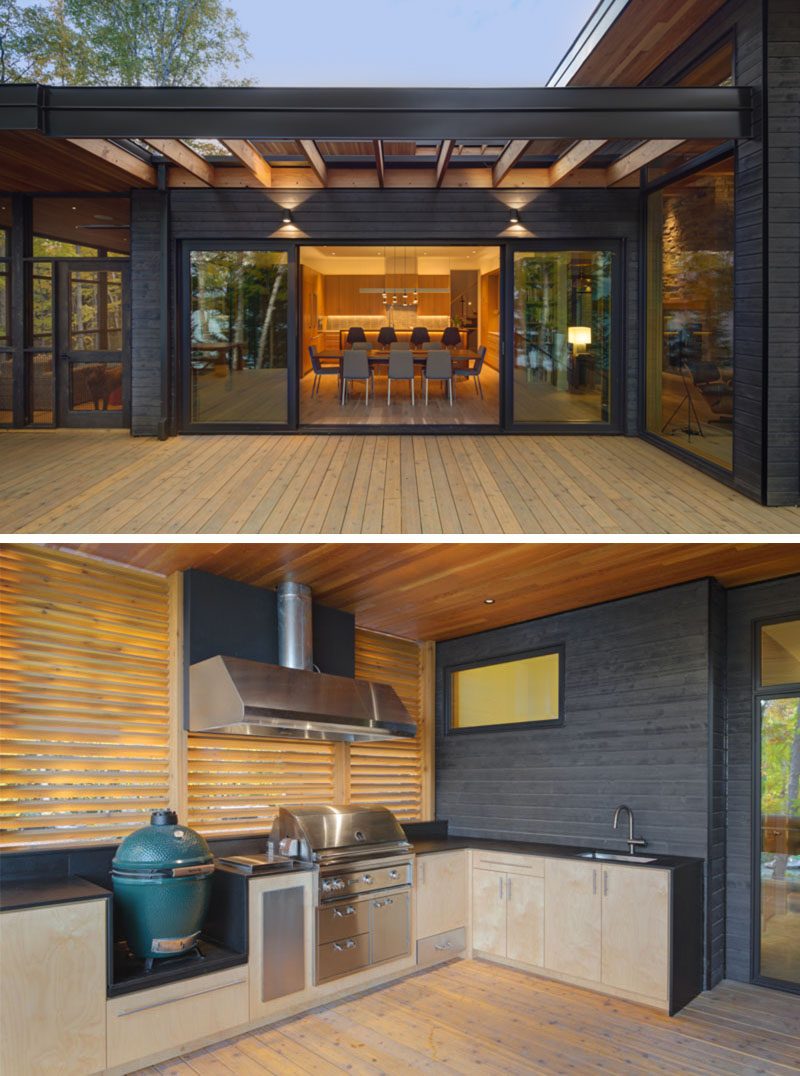 This modern house has an outdoor kitchen with a built-in grill and smoker, that's is adjacent to a screened porch, and is protected by a roof and privacy screen. #OutdoorKitchen #ModernHouse #Deck