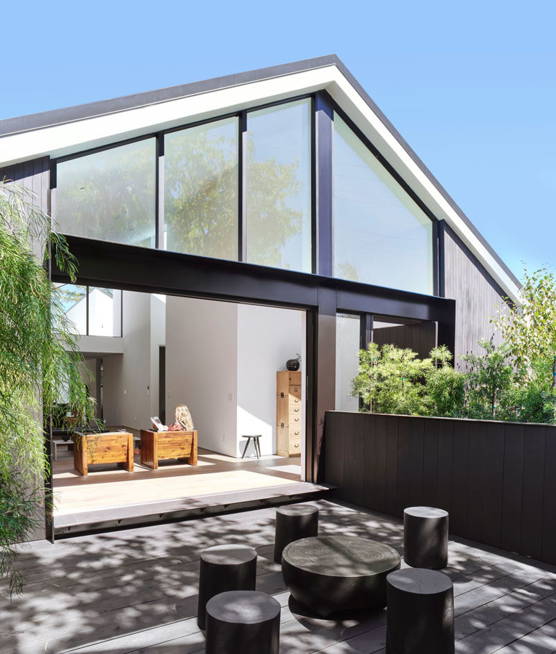 This modern house has a foyer that leads to the living room that features sliding glass doors that open to a private courtyard at the front of the home. #Courtyard #OutdoorSpace