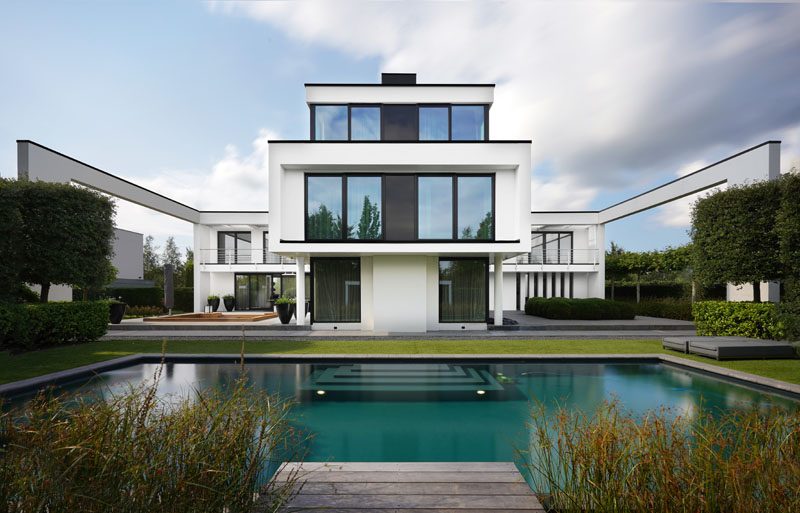 The outdoor areas of this modern house include a sunken lounge, a partially covered dining area, and a pool with a cabana. #Architecture #Landscaping #OutdoorLounge #SunkenLounge #SwimmingPool