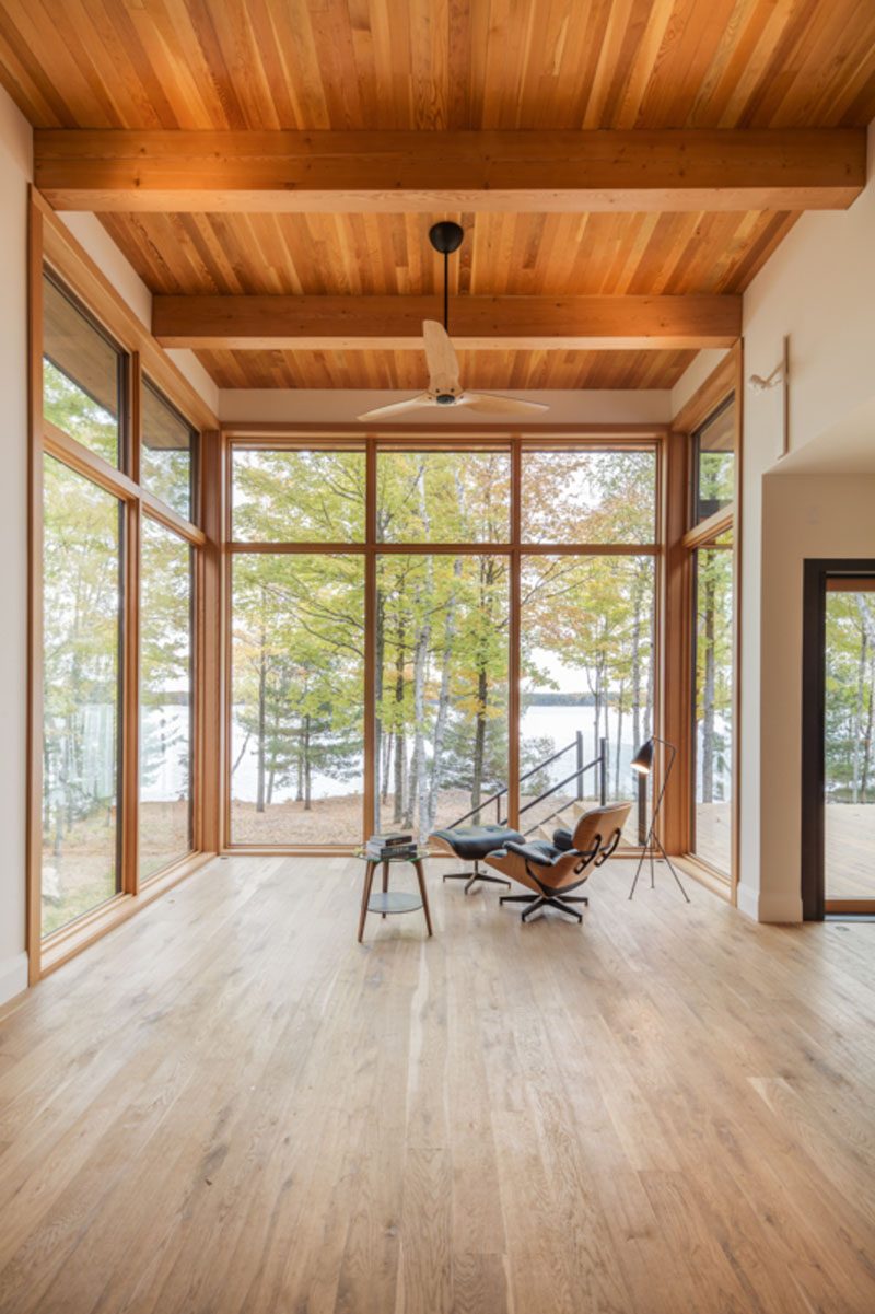 The material palette throughout this modern lakeside house features Douglas fir windows and ceilings, with white oak cabinetry, and concrete and oak floors. #WoodCeiling #ModernHouse #Windows #HouseInterior #WoodFloors