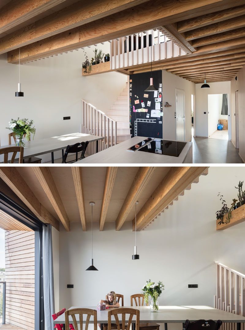 Inside this modern house, there's an open plan kitchen and dining room, as well as a couple of bedrooms and the bathroom. Throughout the home, the structural wooden beams were kept visible as much as possible. #ModernHouse #HouseDesign #DiningRoom