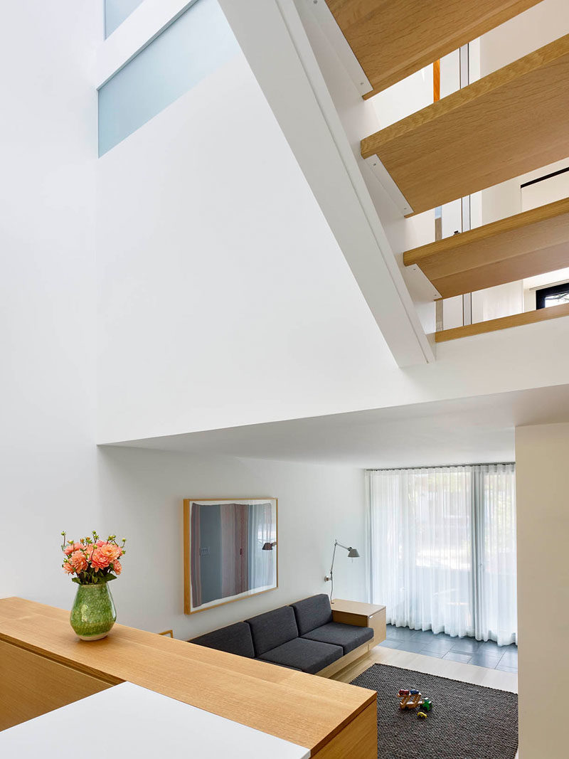 This modern house has a split level-design, with the library sunken down from the kitchen and dining room. Both areas receive plenty of sunlight from the light well above. #Architecture #ModernHouse #Stairs #LightWell