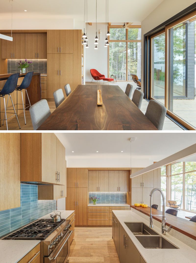 This modern lakeside house features large social spaces designed to host the extended family, with a spacious kitchen and dining room that connect to the screened porch by way of a large sliding door that pockets into the wall. #ModernDiningRoom #ModernKitchen #KitchenDesign #BlueTileBacksplash #WoodKitchen