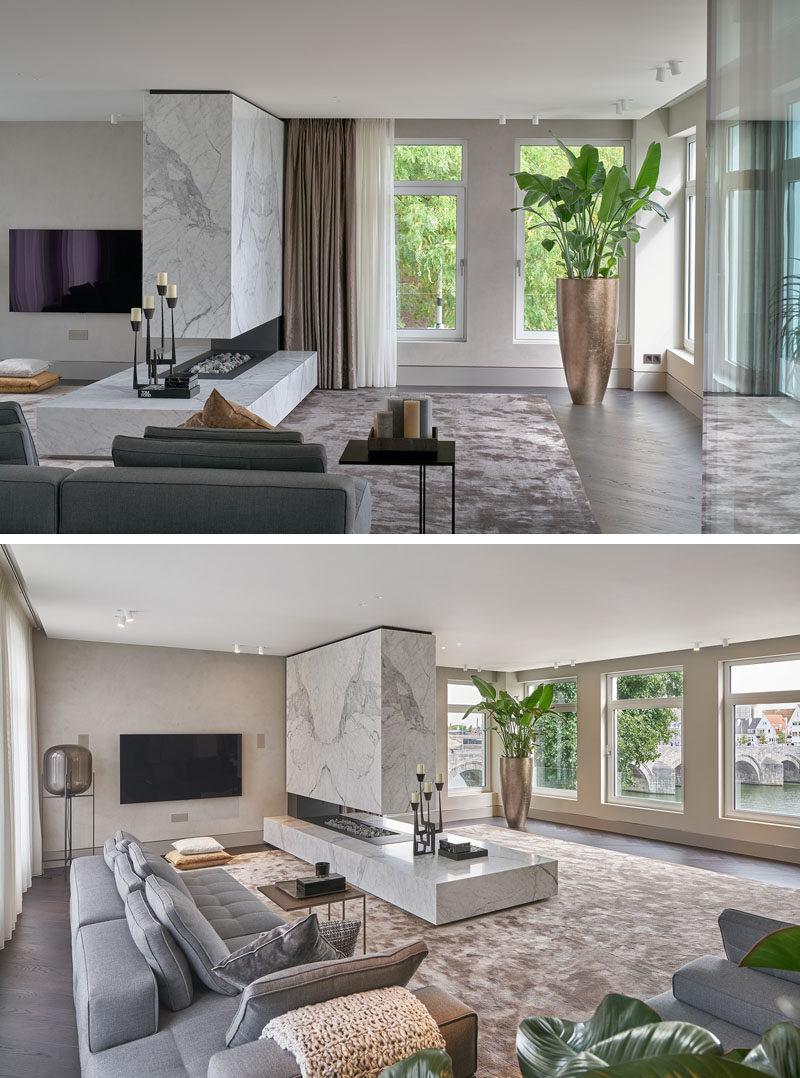 Fireplace Ideas - In this modern living room, a large open fireplace is finished in statuario marble, creating a focal point in the open interior. #ModernFireplace #OpenFireplace #FireplaceIdeas
