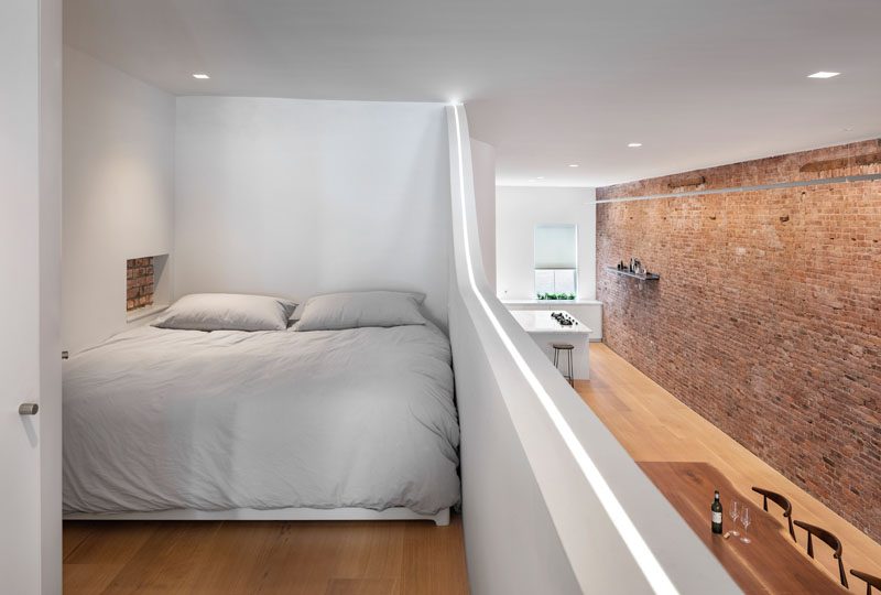 This modern loft has a mezzanine that's home to a king size bed, and has a small shelving niche that acts as a bedside table. #Mezzanine #Loft #Apartment #Bedroom