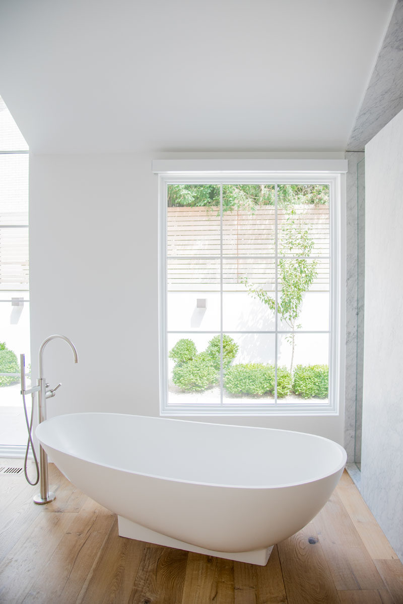 Bathroom Ideas - This modern master suite has a sculptural freestanding bathtub, that's also positioned to take in the garden views. #BathroomIdeas #FreestandingBathtub