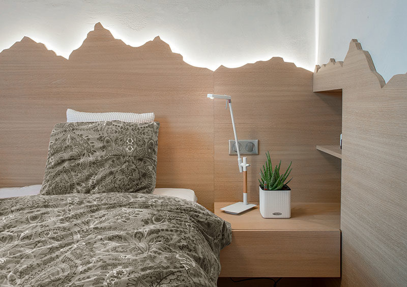 headboard Ideas - Using a mountain range as inspiration, this custom wood headboard with hidden lighting showcases the outline of the mountains and creates a soft glow for the bedroom. #HeadboardIdeas #ModernHeadboard #BedroomIdeas #BacklitHeadboard #ModernBedroom