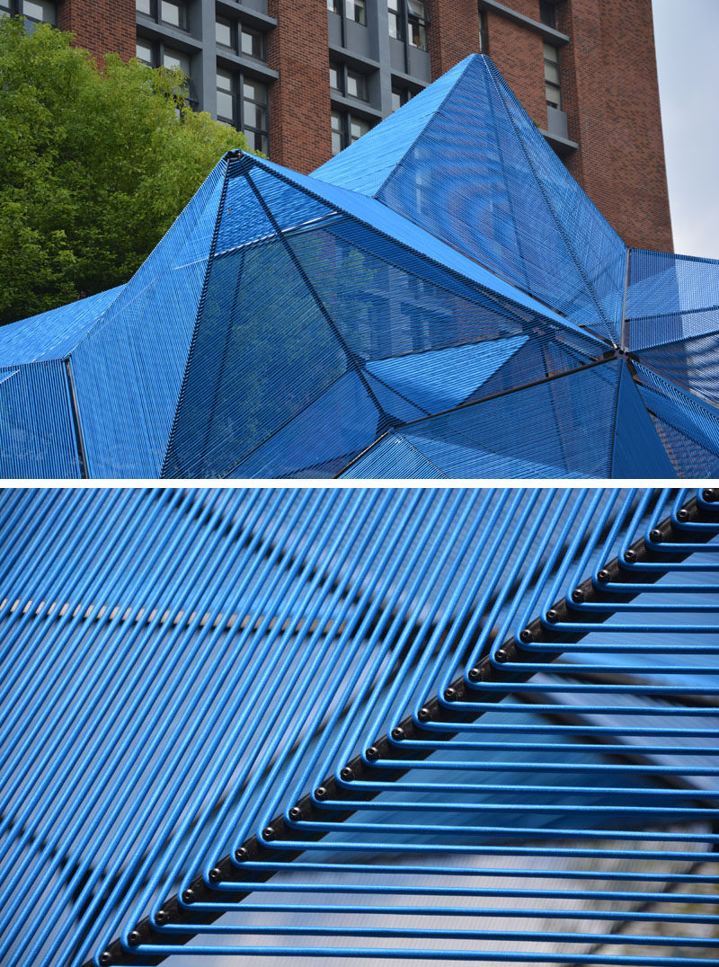 This modern public art installation named 'Cobalt Muffin', has a geometric shape that floats over a lawn, with the design made from 60 similar triangles, that have been covered with a semi-transparent skin made from more than 4 miles (7.5 km) of elastic ropes, creating a vibrant addition to the area. #ModernArt #ArtInstallation #PublicSculpture