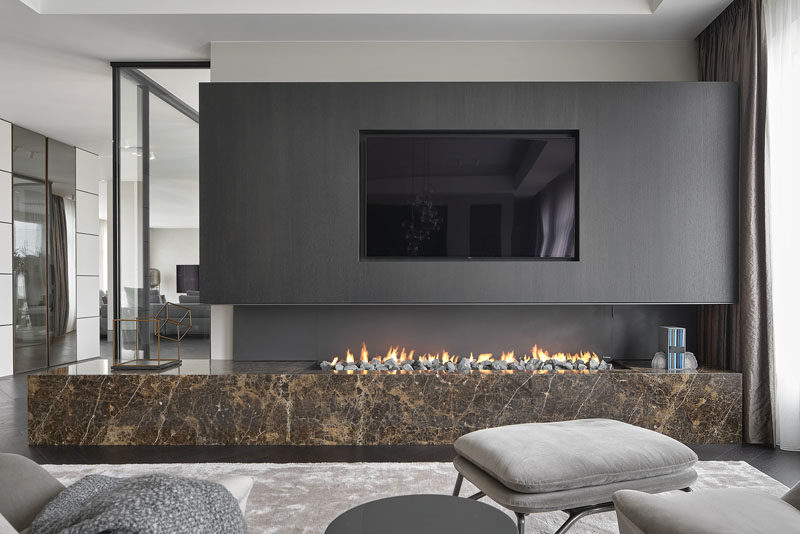 Fireplace Ideas - This modern sitting area is focused on the recessed television and the open linear fireplace below. #FireplaceIdeas #LinearFireplace #RecessedTV