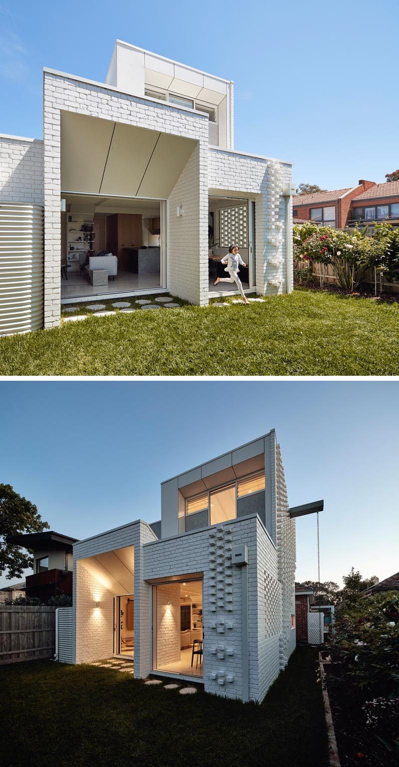 Both the dining area and the living room of this modern white brick house extension open up to the yard, where floating concrete pavers have been used to eliminates the need for expensive decking and poured concrete pathways. #ModernHouseExtension #WhiteBrick #PaintedBrick #Landscaping