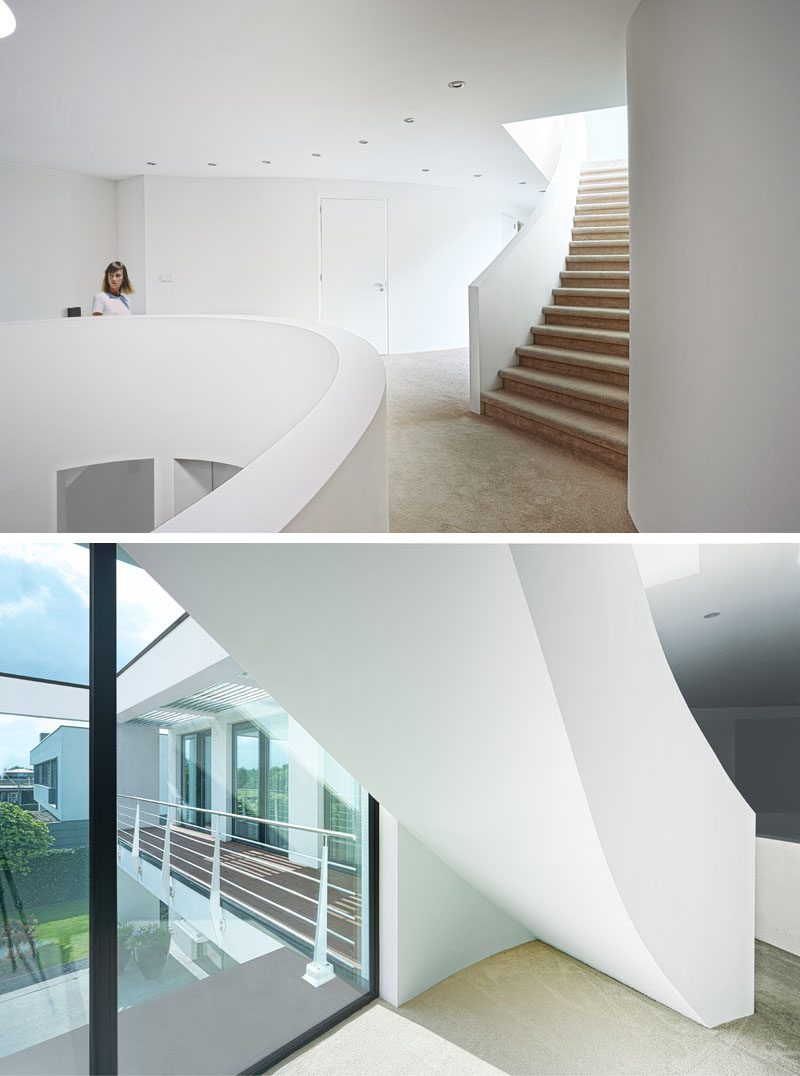 The interior of this house has been kept minimal with bright white walls, while curving stairs add a sculptural element and connect the various levels of the house. #Staircase #CurvingStairs #SculpturalStairs