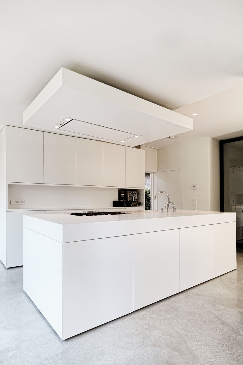 Kitchen Ideas - This all-white kitchen makes use of minimalist cabinets and thick countertops. #ModernKitchen #KitchenIdeas #ModernWhiteKitchen #MinimalistKitchen #WhiteKitchen