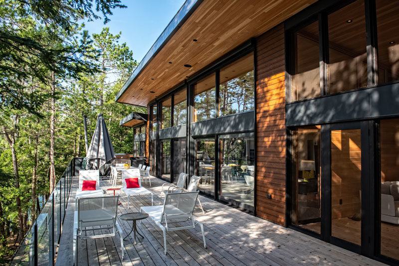 This modern cottage has a pair of oversized patio doors with retractable screens allows the interior spaces to open to the outdoors during the summer and provides natural ventilation. #ModernCottage #Architecture #ModernHouse