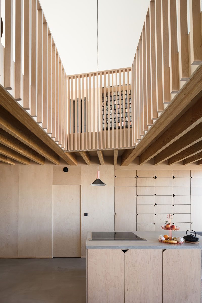 This modern kitchen has hardware free wood cabinets with small angled cutouts in the corners that allow them to be easily opened. #WoodKitchen #ModernKitchen #KitchenDesign