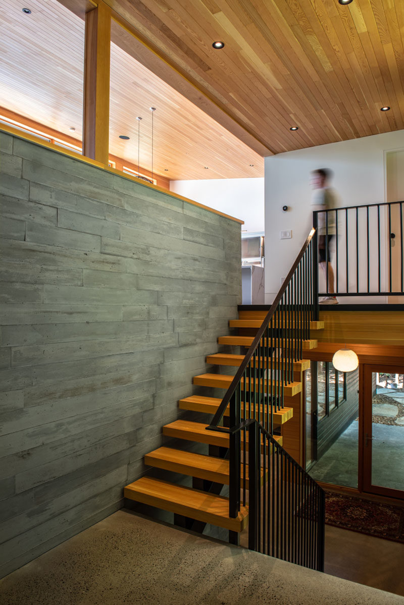 Stair Ideas - Throughout the house, polished concrete floors provide both thermal mass and durability, while Douglas fir windows and ceilings add warmth to the interior. Wood and metal stairs lead to the main living spaces on the upper level of the home. #WoodStairs #ModernStairs #PolishedConcreteFloors #ConcreteWall #DouglasFir #WoodCeiling