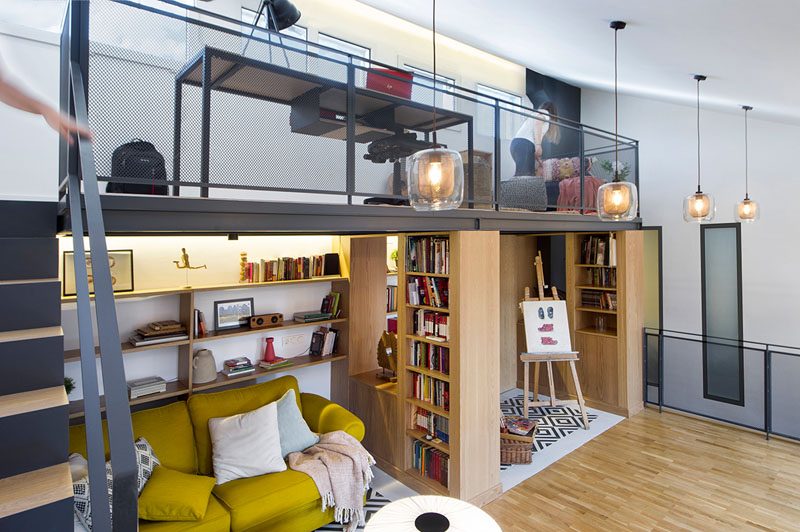 This modern attic has a mezzanine that's been furnished with a desk and sitting area, making it an idea space for homework or an office. #ModernAttic #Mezzanine #HomeOffice #Library