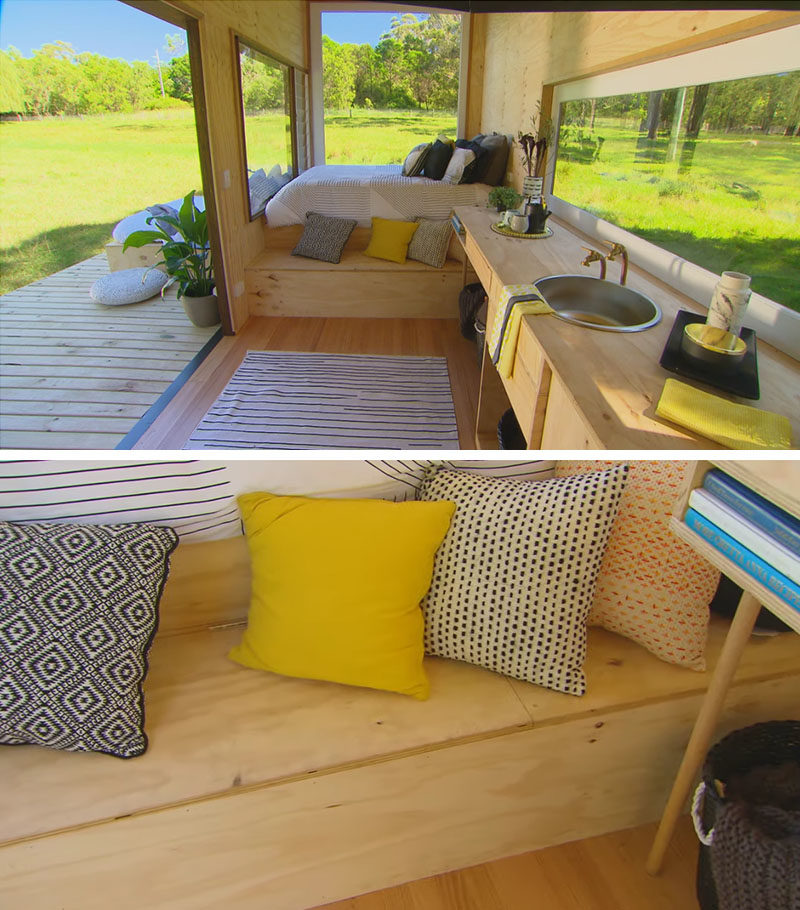 Tiny House Ideas - Inside this modern tiny house, there's a raised bed at one end, that takes advantage of the window views. A small bench that doubles as a step, also provides additional storage. #TinyHouseIdeas #ModernTinyHouse #TinyHouseBedroom #TinyHouseStorage