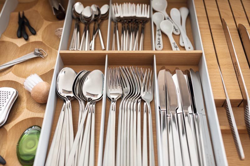 Kitchen Organization Ideas - This modern and modular drawer design combines removable trays, inserts, dividers, knife blocks, spice jars, and foil rolls that can be configured individually. A special solid-wood chopping board can also be integrated into the  drawer fittings. #KitchenOrganization #KitchenDrawerDesign #KitchenDesign 