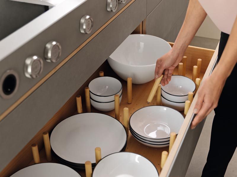 Instead of keeping plates and bowls in cupboards this kitchen drawer design has wood separators that can be moved depending on the size of the dinnerware. #KitchenOrganization #KitchenDrawers #DinnerwareStorage