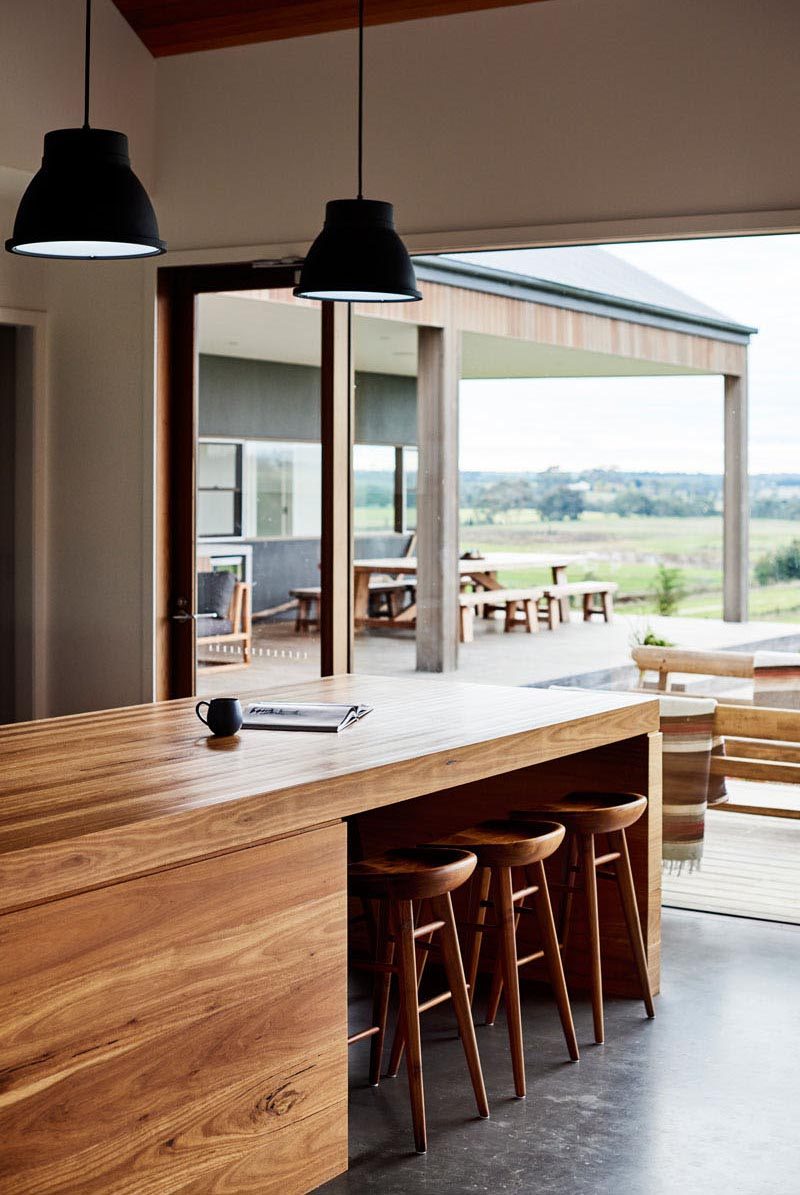 For casual kitchen seating, counter stools create a way for someone to keep the cook company. As they're often counter height, kitchen islands are often designed with a cut out or overhang to allow the stools to be neatly tucked away when not in use. #KitchenIslandSeating #KitchenIslandDesign #KitchenDesign #KitchenIslandIdeas