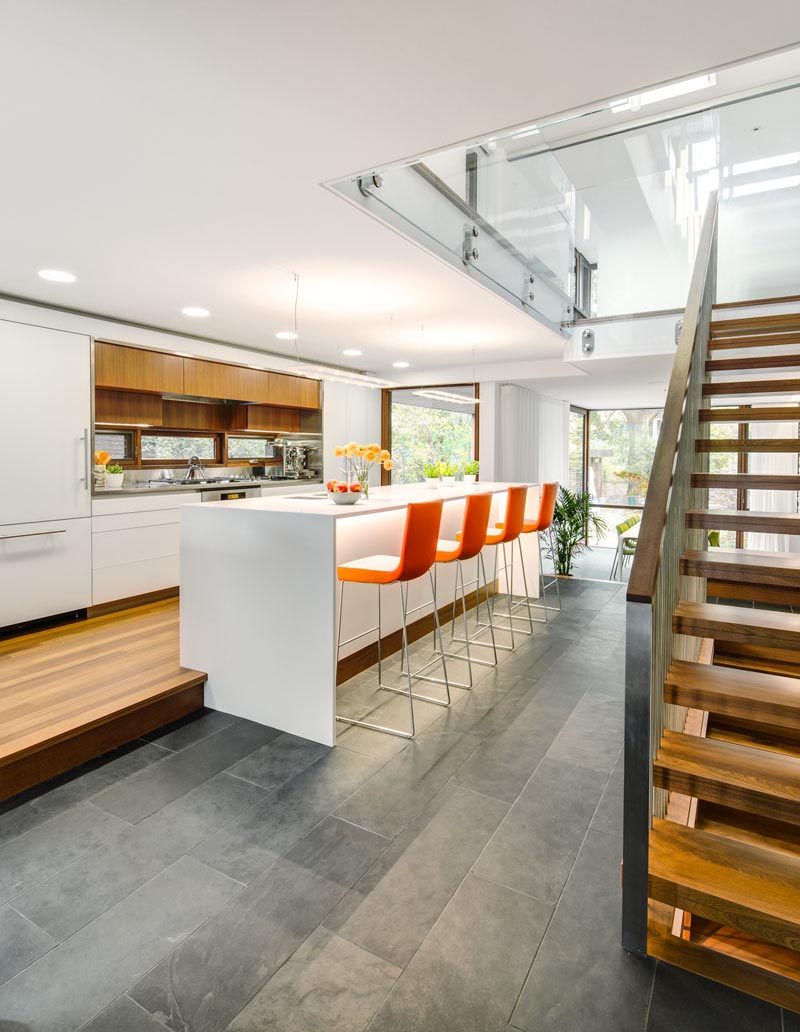 Some homes have their kitchens raised, creating enough room to add bar stools to the island on a lower level of flooring. #KitchenIslandStools #KitchenDesign #KitchenIslandIdeas