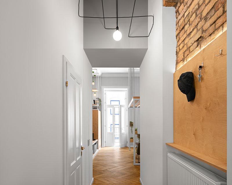 The hallway in this apartment has glimpses of the original brick construction, leads from the entryway to the main living area and bedrooms. #Hallway #InteriorDesign