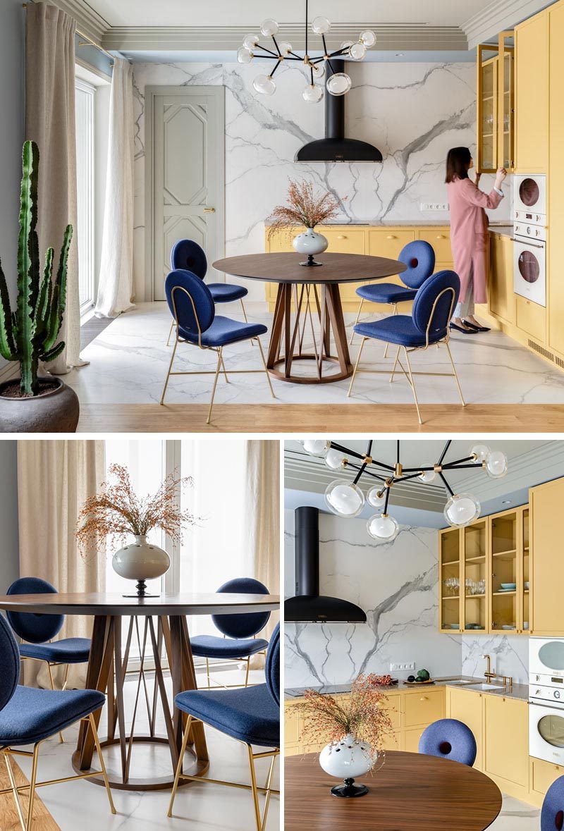 This modern kitchen has matte yellow cabinets with built-in white Smeg appliances, while the wood dining table and cacti add a natural touch to the interior. #YellowKitchen #ApartmentKitchen #KitchenDesign