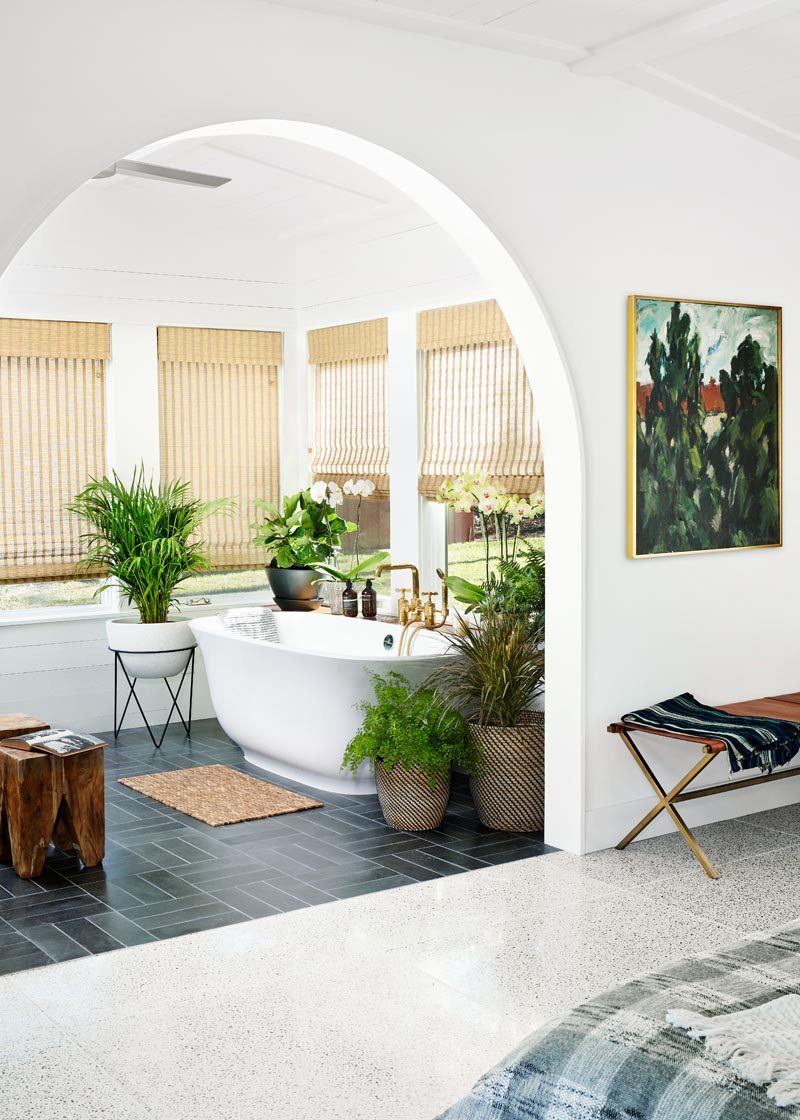 This sunroom, located off the bedroom, has been outfitted with a freestanding tub that enjoys expansive views to the wide open lawn of the backyard. #Sunroom #Bedroom #BathroomDesign