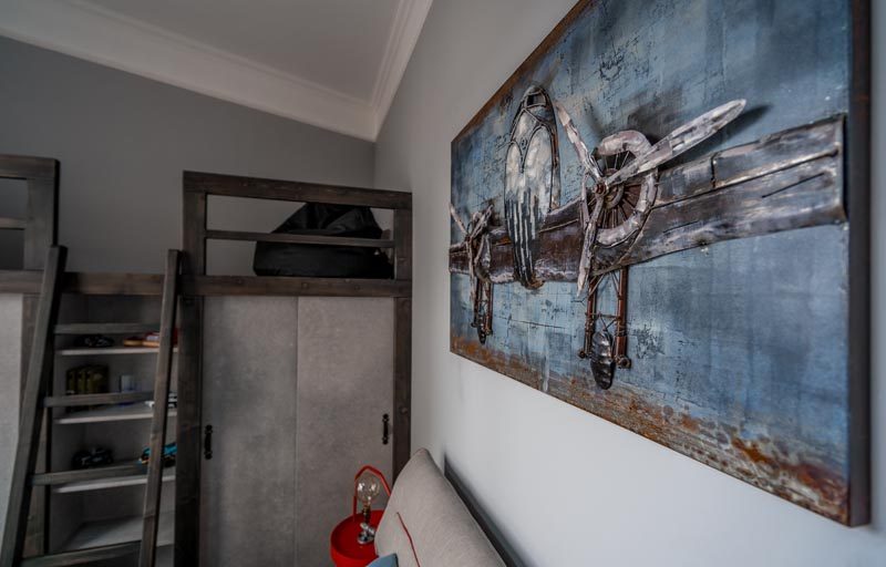 This modern bedroom has a lofted sitting area above the closets, that's accessed by a small ladder and furnished with beanbags. #LoftedLounge #BedroomDesign #BedroomIdeas #ModernBedroom #Loft #Closets