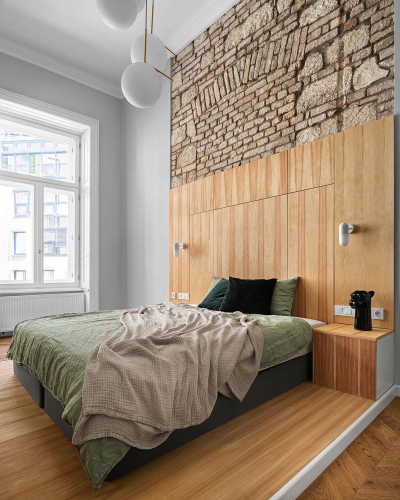 This modern apartment has a bedroom with high ceilings that allow the original brick and stone work to be shown, while the bed has been placed on a platform, designating the sleeping area. #Bedroom #ModernBedroom #BedroomDesign