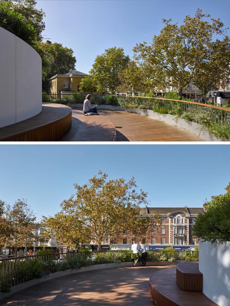 This modern rooftop garden features timber decking, while large planters embedded within the spiraling shape of the building, introduce diverse and luscious herbal planting, promoting biodiversity and creating a comfortable environment. #RooftopGarden #RooftopDeck #RestaurantRooftop #Landscaping