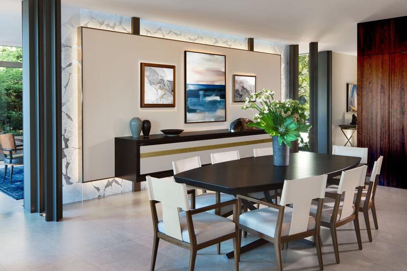 This modern dining room has a wall specifically designed to display artwork. #DiningRoom