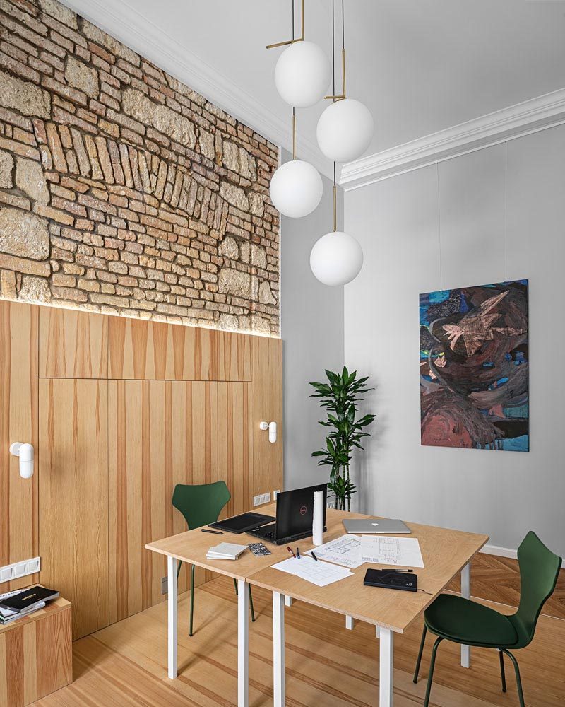 This modern apartment has a room dedicated to a home office, that has high ceilings and original brick details. #HomeOffice #InteriorDesign