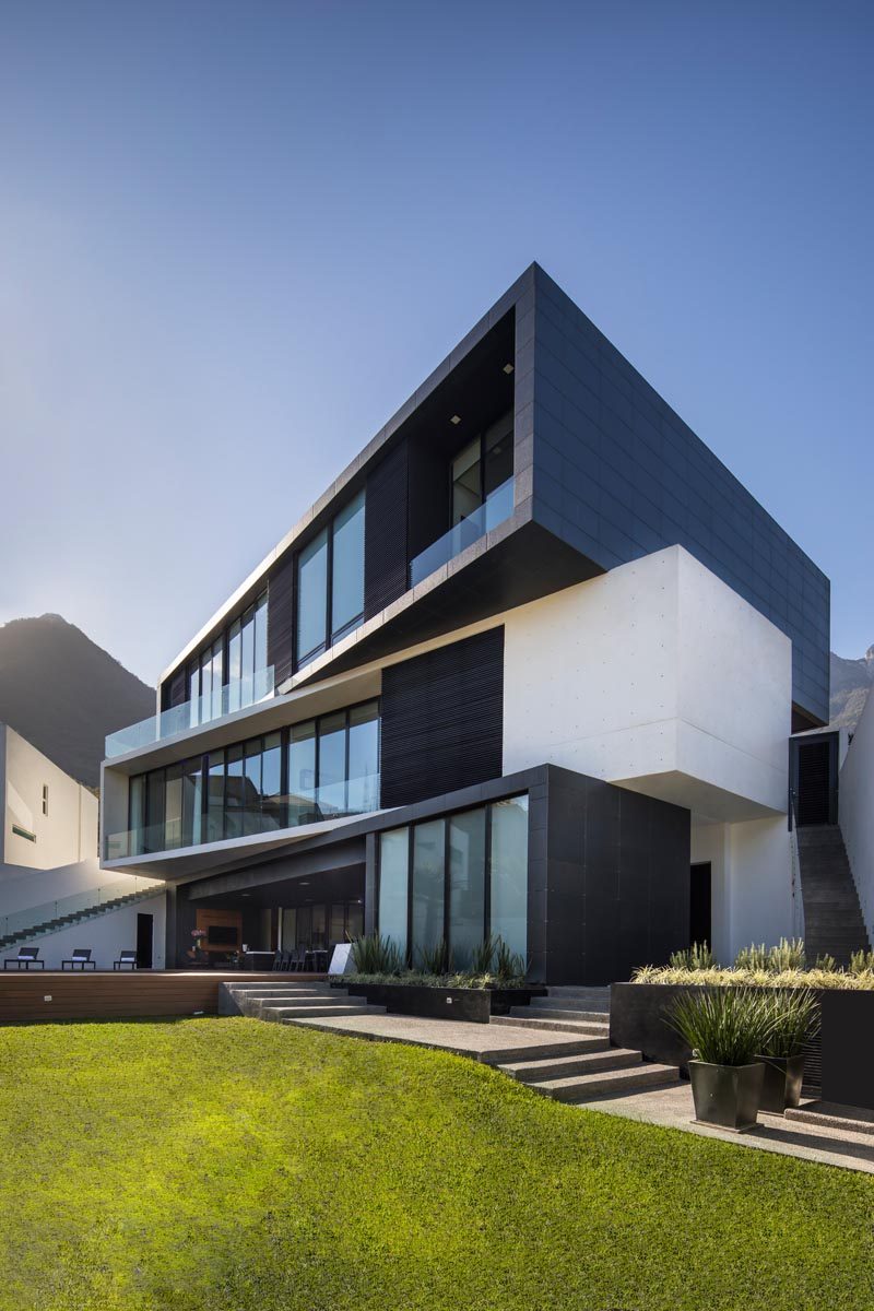 The three rectangular volumes have been rotated and shifted to create a more angled appearance for this modern house, with the lighter middle section separating the two darker levels. #ModernArchitecture #ModernHouse #HouseDesign #Balconies