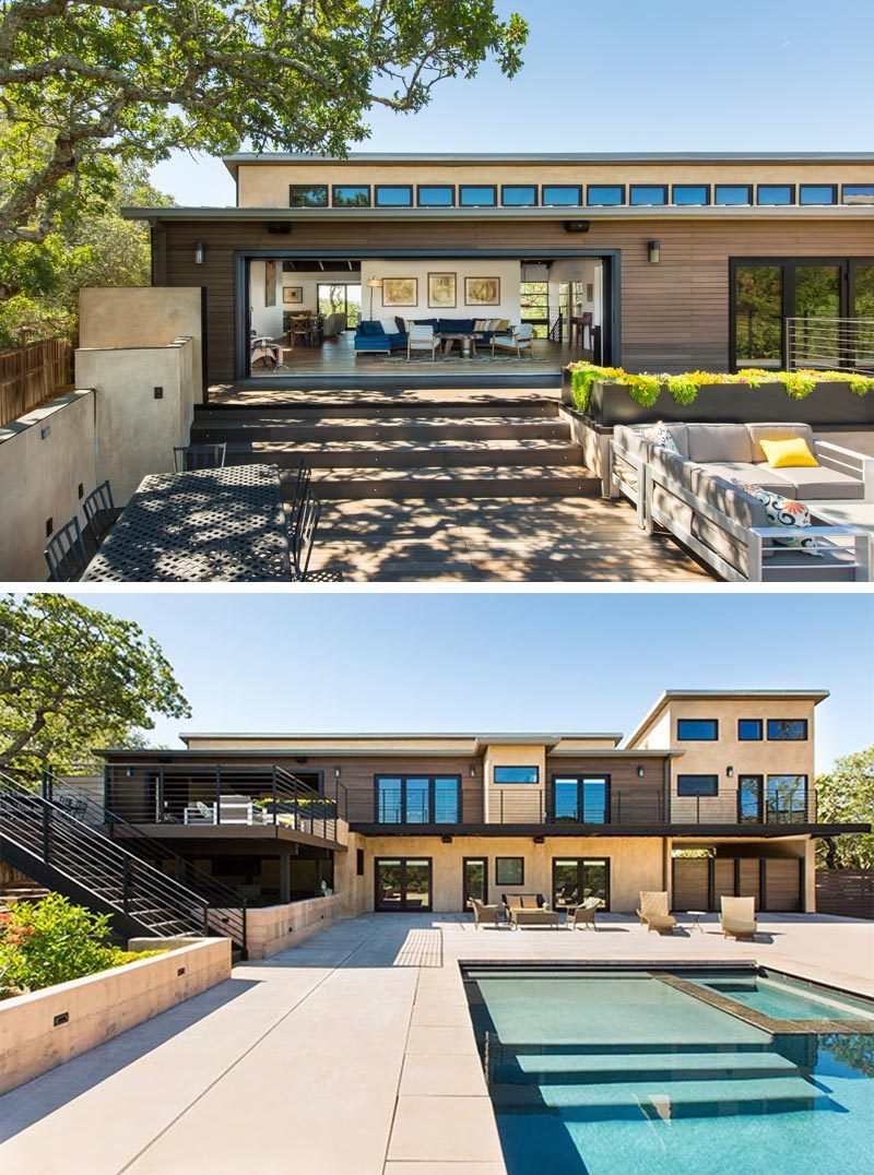 This modern house has a deck that leads down to an alfresco dining area and outdoor lounge, while stairs lead even further down to a swimming pool. #OutdoorSpace #Architecture #Landscaping