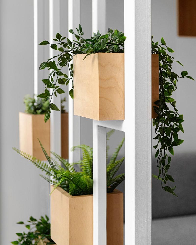 A white painted steel frame provides a place to display a few plants in wood boxes. #ModernPlanters #Decor