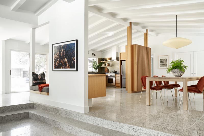 Just off the the dining area in this renovated mic-century ranch house, is a small built-in reading nook, while sliding glass doors connect to the outdoors. #ReadingNook #MidCenturyInterior