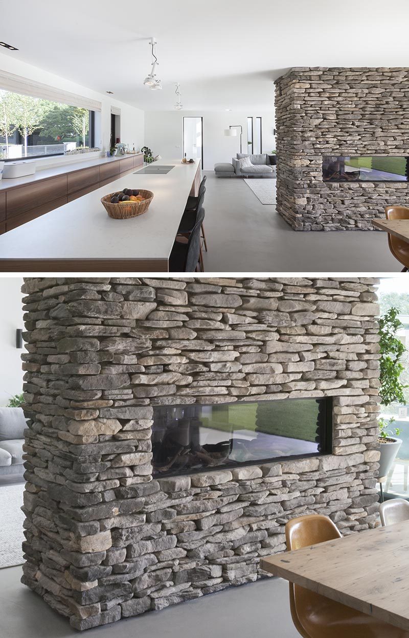 Apart from separating the dining area and living room, this stone accent partition is home to a linear fireplace on the dining room side, and on the opposite side, a built-in television with storage below. #StonePartition #StoneFireplaceSurround #StoneWall