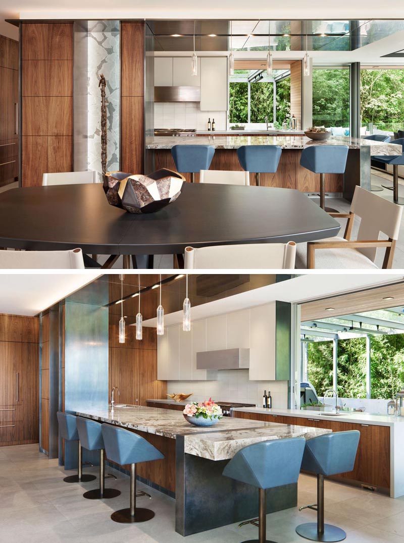 In this modern kitchen, a large peninsula with steel accents provide a place for casual seating. #ModernKitchen #KitchenDesign