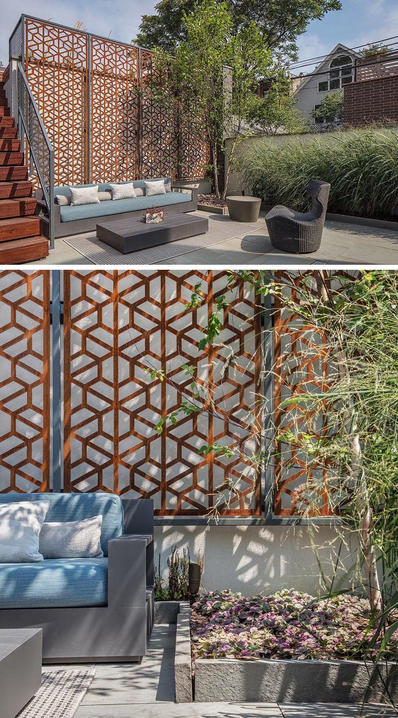 A modern but earthy vibe has been created with multi-level outdoor areas, field stone, and a custom raw steel screen, that has weathered over time and acts as a backdrop for a outdoor living room. #LandscapingIdeas #BackyardIdeas #YardIdeas #Terrace #OutdoorLounge