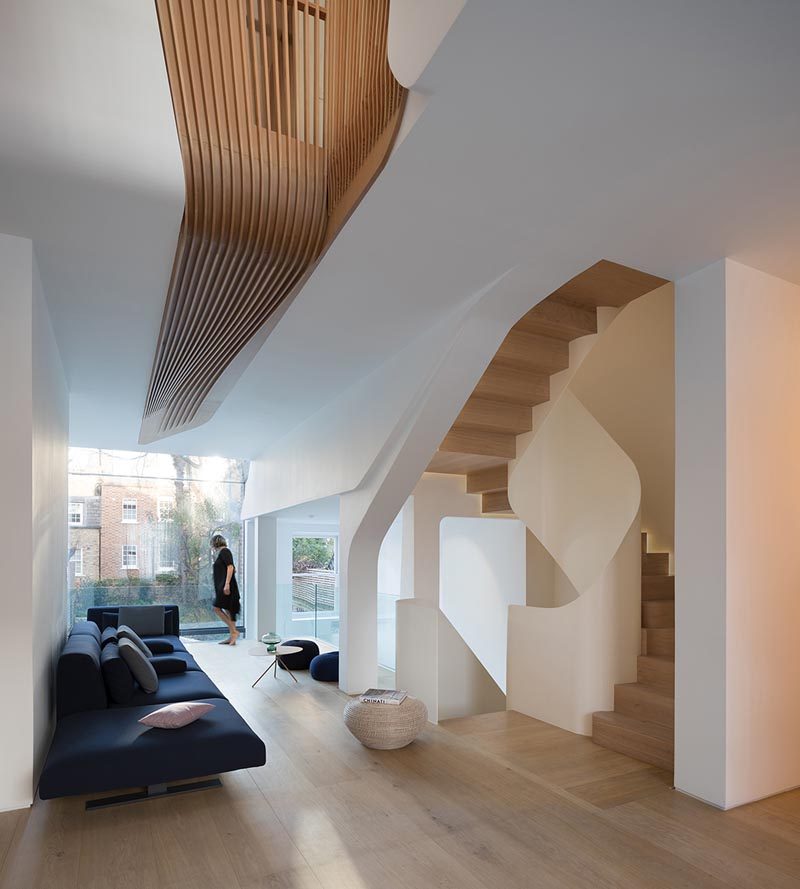 This modern house features wood floors, wood slat accents, and a spiraling staircase. #InteriorDesign #WoodFloors #Staircase