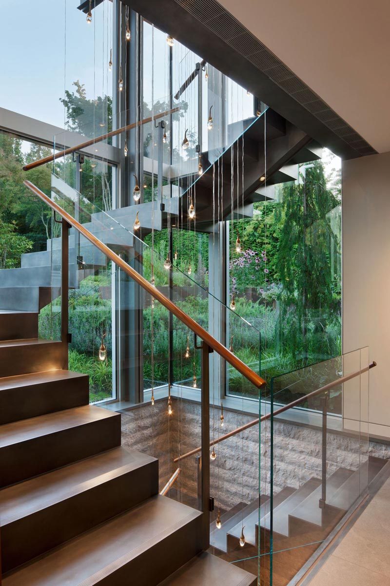 Steel stairs surrounded by windows connects the various levels of the house. #SteelStairs #StairDesign