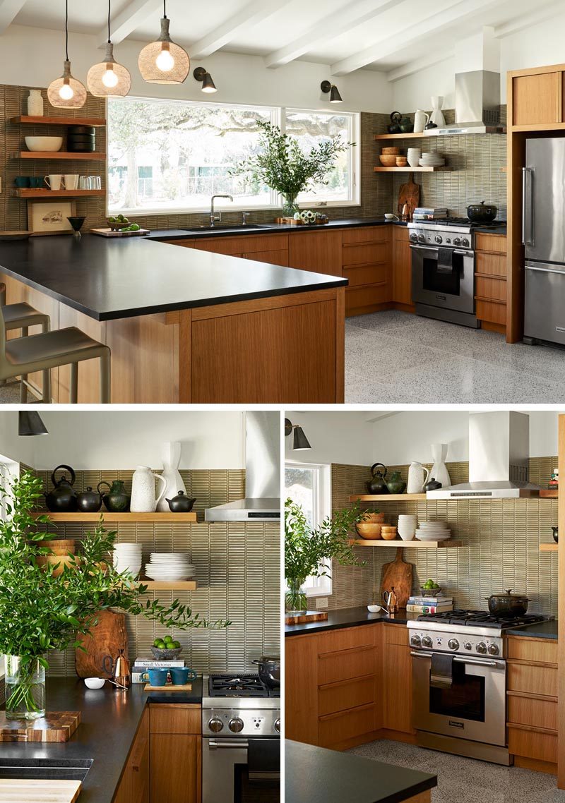 In this modern kitchen, wood cabinets, black countertops, and earth-tone tiles were used, while the large window provides an abundance of natural light. #ModernKitchen #WoodKitchenCabinets #BlackCountertops